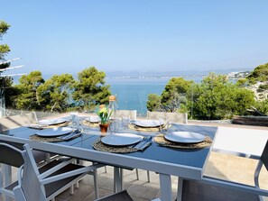 Mesa para cuatro con vistas al mar y a las montañas.