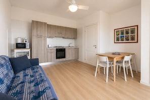 A compact living space with a kitchenette, a dining area, and a sofa.