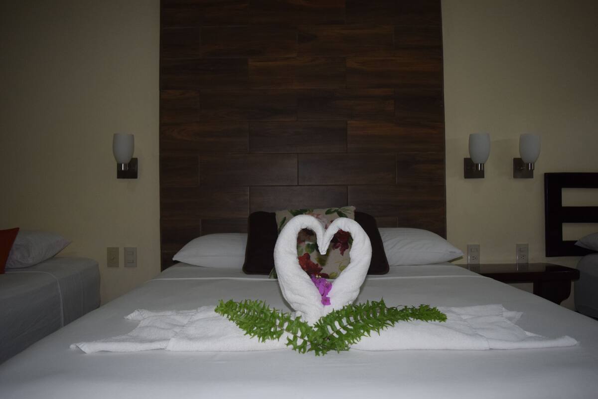 A hotel room with a bed, two nightstands, and a wooden headboard.
