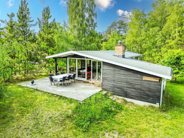 Una casa moderna con un porche cubierto, comedor y chimenea.