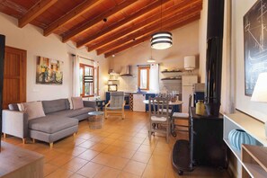 A spacious living area with a sofa, dining table, and kitchen area.