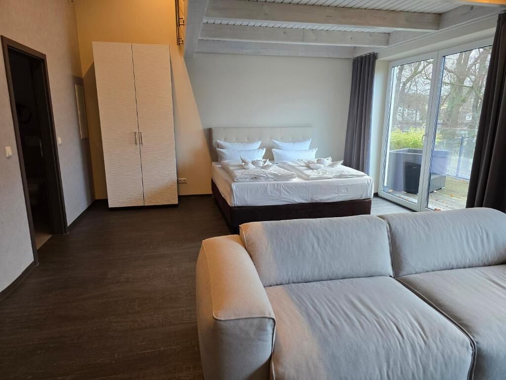 Une chambre d’hôtel moderne équipée d’un lit, d’un canapé et d’une armoire.