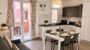 A modern kitchen with a dining area, a sofa, and a view of the outside. - New Construction,  beautiful 2 bed apartment facing the sea, Wi-fi ,Aircon (La Ciaccia)