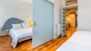 A bedroom with a bed, a wardrobe, a radiator, and a staircase leading to an upper level. - UNIQUE DUPLEX PENTHOUSE & FREE PARKING (Porto)