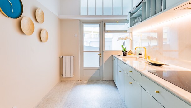 A modern kitchen with a large window, a built-in oven, and a white countertop. - UNIQUE DUPLEX PENTHOUSE & FREE PARKING (Porto)