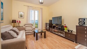 A living room with a sofa, a coffee table, a TV, and a cabinet. - Vera Seaview Apartment (Zadar)