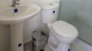 A bathroom with a sink, toilet, and glass-enclosed shower. - Exclusive Vacation Apartment in Peñalisa (Ricaurte)