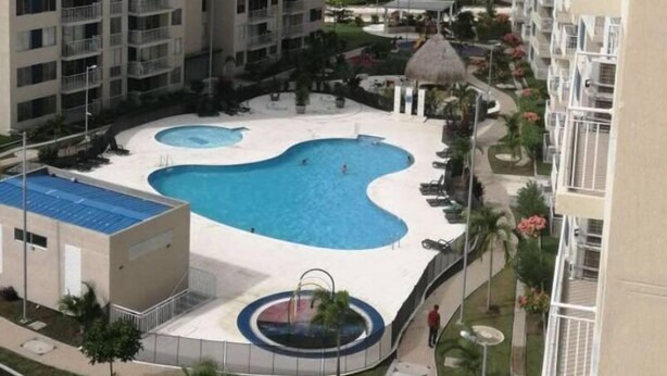 A residential building with a swimming pool and a small circular fountain. - Exclusive Vacation Apartment in Peñalisa (Ricaurte)