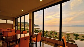 A conference room with large windows overlooking a coastal view.