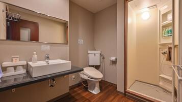 Une salle de bain équipée d’un lavabo, de toilettes et d’une douche à l’italienne.