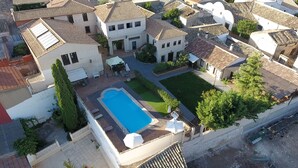 Vue aérienne d’un quartier résidentiel avec de nombreuses maisons, une piscine et un jardin bien entretenu.