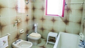 Ein Badezimmer mit Toilette, Bidet, Waschbecken und Badewanne.