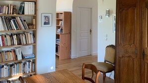 A dining area with a wooden table, chairs, and a bookshelf filled with books.