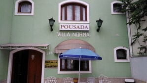 A building named Pousada Villa Norma with a sign indicating it offers bed and breakfast services. - Villa Norma Suites (Vitoria)