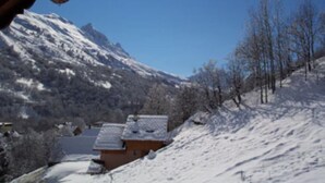 Schneebedeckte Berglandschaft mit einem Gebäude im Vordergrund.