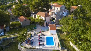 An aerial view of a hillside village with stone houses, a swimming pool, and outdoor seating areas. - Villa Paradise village in Tucepi, private pool (Tucepi)