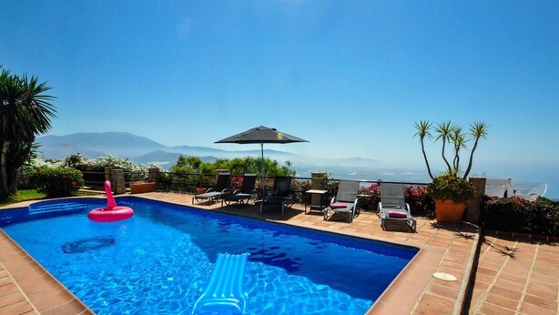 A swimming pool with a view of the ocean and mountains, surrounded by lounge chairs and potted plants. - Luxury villa stunning views, private heatable pool (Salobreña)