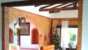 Uma sala de estar acolhedora com piso de azulejos, móveis de madeira e lareira de tijolos.