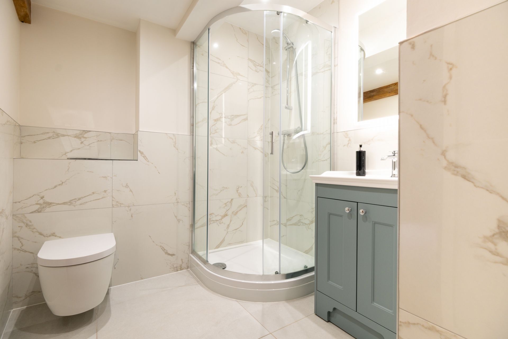 A modern bathroom with a glass-enclosed shower, a toilet, and a vanity with cabinets.