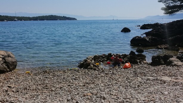 A rocky shoreline with clear water, boats, and distant mountains. - Apartment Penthouse by the sea - Vrboska - Island Hvar (Vrboska)
