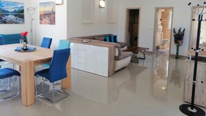 A modern living room with a dining area, a sofa, a coffee table, and a TV. - Apartment Penthouse by the sea - Vrboska - Island Hvar (Vrboska)