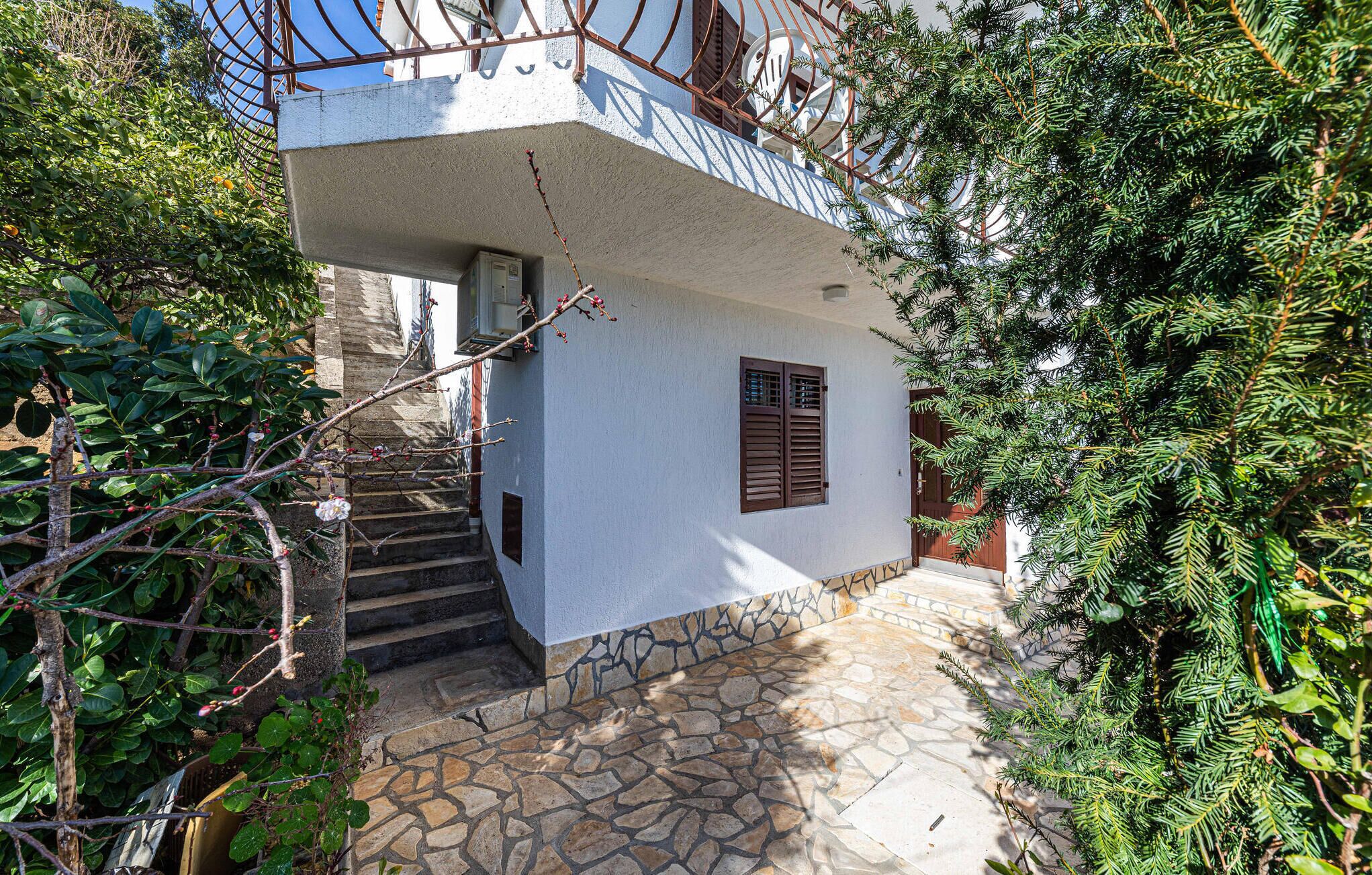 A white building with a stone staircase leading to a wooden door.