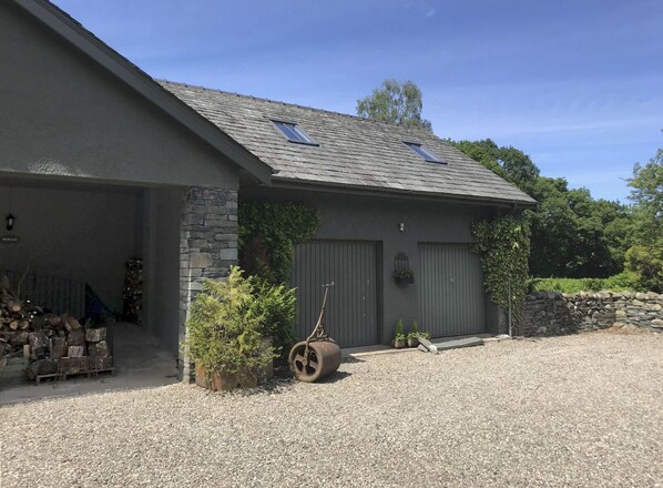 Un bâtiment à deux étages, doté d’un toit en pente, de fondations en pierre et d’une allée gravillonnée.