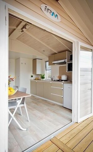 Kitchen area with microwave, dining table, and potted plant.