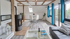 Ett modernt vardagsrum med en öppen spis, en matplats och en soffa.