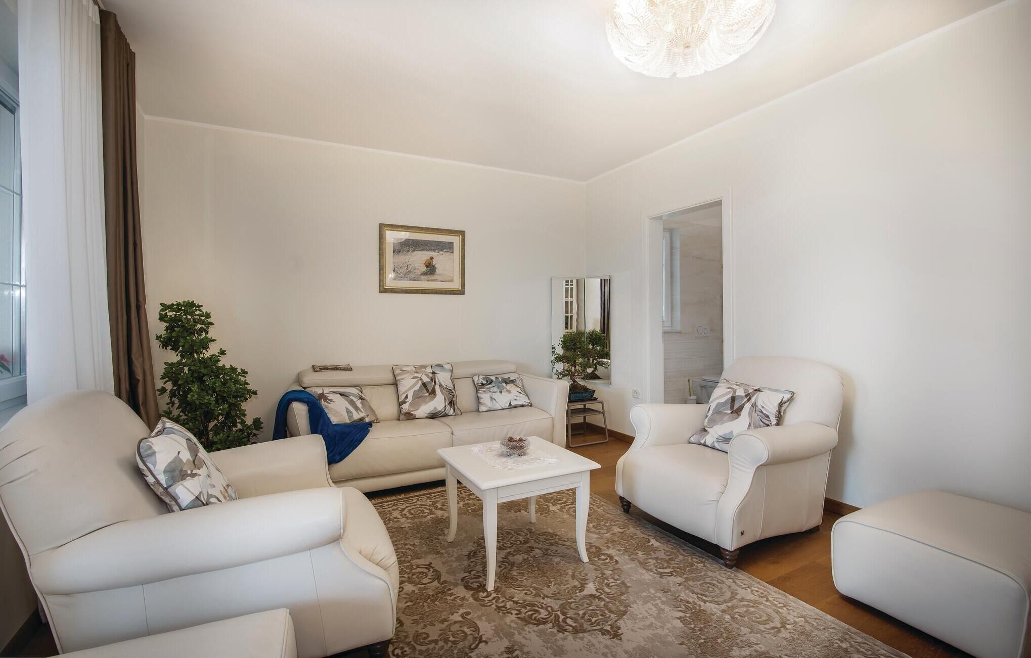 A modern living room with a sofa, two armchairs, a coffee table, and a decorative mirror.