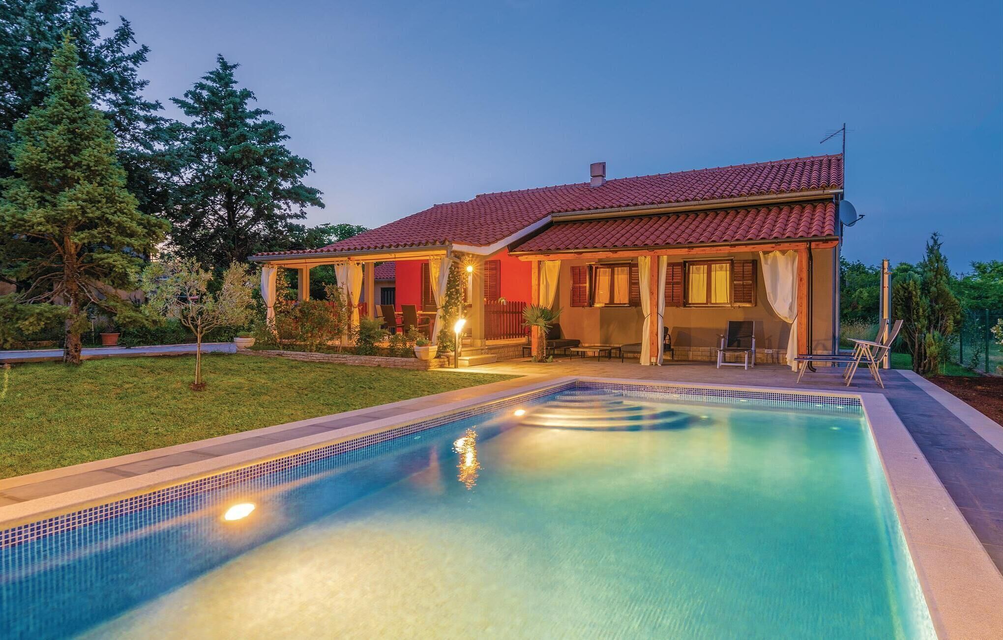 A two-story house with a swimming pool, outdoor seating, and a garden.