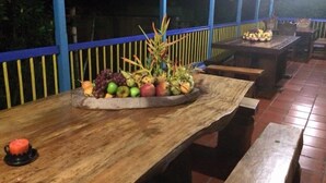 A wooden table with a fruit platter and a candle. - Finca Hotel La Joya (Calarcá)