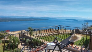 Un balcón con vistas a una gran extensión de agua e islas lejanas.