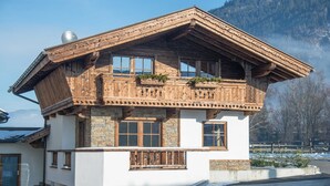 A chalet-style building with a sloped roof, wooden balconies, and large windows. - Double room - Ferienhof Stadlpoint (Ried im Zillertal)