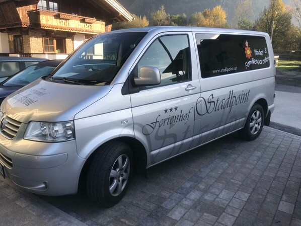 A silver van with 'Kinder- & Familienparadies' and 'Stadtpunkt' branding, parked on a paved surface.