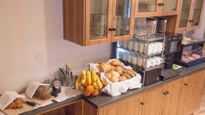 A breakfast buffet with bread, pastries, and fruits. - Double room - Ferienhof Stadlpoint (Ried im Zillertal)