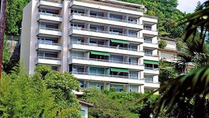 A multi-story building with balconies, surrounded by lush greenery. - Castagnola (Utoring) by Interhome (Castagnola)
