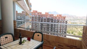 A balcony with a tiled table, chairs, and a bottle of wine. - Torre Maestral by Interhome (Benidorm)