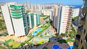 A high-rise residential building complex with multiple balconies, a central courtyard with a swimming pool, and a view of the sea. - Torre Maestral by Interhome (Benidorm)