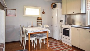 A compact kitchen with a dining table, chairs, a refrigerator, a stove, and a microwave. - Awesome home in Ryd with house sea view (Ryd)