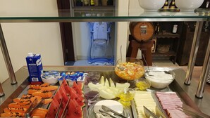 A buffet with various food items including fresh fruits, dairy products, and meats. - Hotel das Palmeiras (Paracatu)