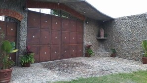 Un bâtiment rustique avec une façade en pierre, une grande porte en bois et des plantes en pot.