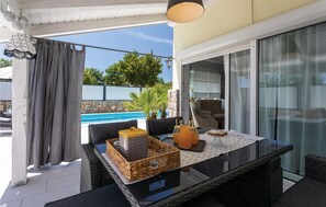 Enjoy al fresco dining with a view of the pool and surrounding landscape.