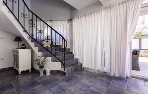 Stairs lead to a stylish space with a cabinet, lamp, and decorative vase.