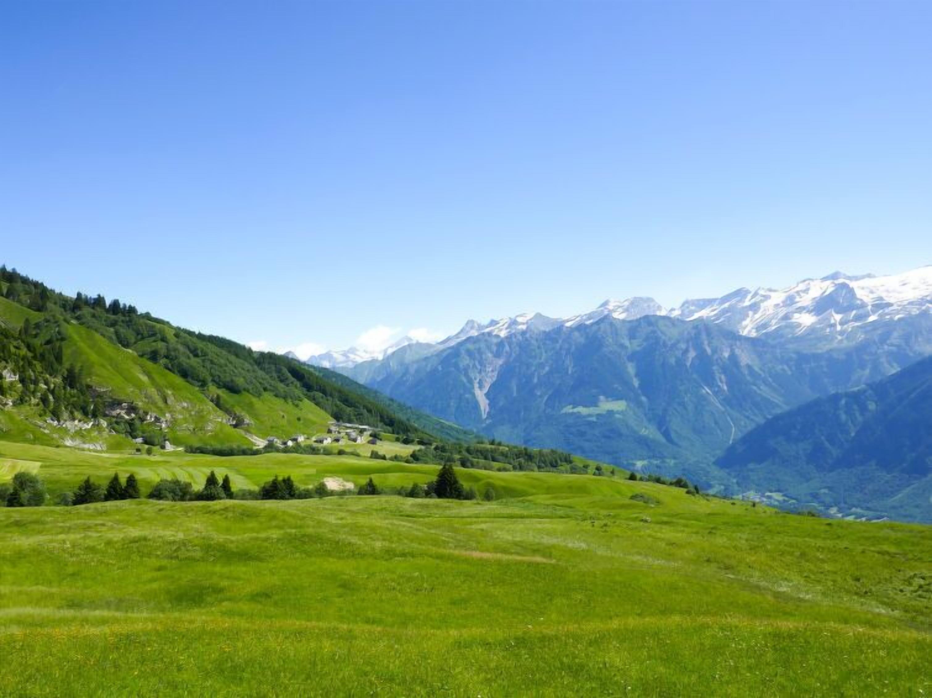 Paisagem montanhosa com um vale e um pequeno povoado.