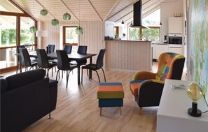 Cozy dining area with a dark table and chairs, a colorful sofa, and a wooden floor.