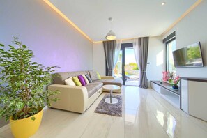 Relax in this stylish living room with a sofa, flat-screen TV, and a view of the outdoors.
