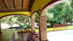 A covered outdoor area with a pool table, lounge chairs, and a bench. - Quinta Comala (Comala)