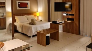 Habitación de hotel moderna con cama, escritorio, televisor y baño a la vista.