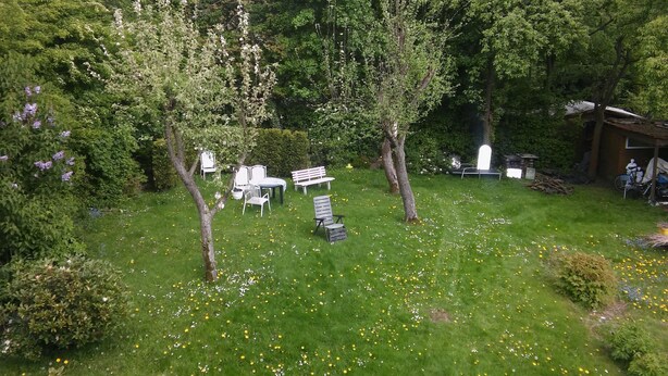 A garden with white chairs and tables, surrounded by trees and a building. - 1 room apartment, ground floor, in the 2 Fam.House with garden, GE.-Buer (Gelsenkirchen-Buer, Gelsenkirchen)